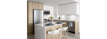 A modern kitchen with a white island and bar stools.