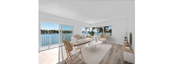 A living room with a white couch and a wooden chair.