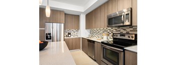A modern kitchen with wooden cabinets and stainless steel appliances.