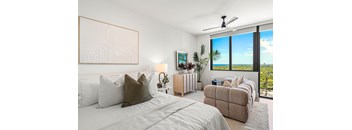 A bedroom with a large bed and a view of the ocean.