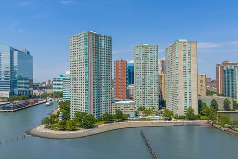 A cityscape with a body of water in the foreground and buildings in the background.