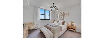 A bedroom with a large bed and a window.