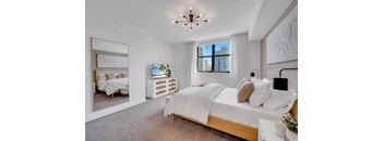 A bedroom with a large bed and a view of the city.