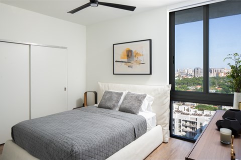 A bedroom with a large bed and a view of the city.