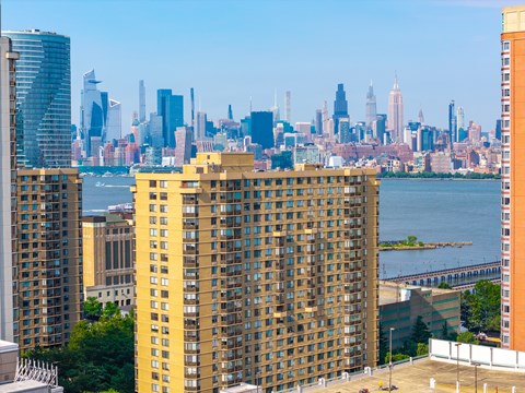 A cityscape with a large yellow building in the foreground.