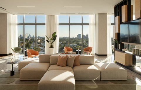A living room with a large sectional sofa and a view of the city.