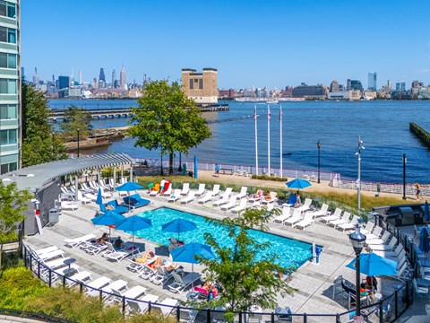 A pool area with a view of the city skyline.