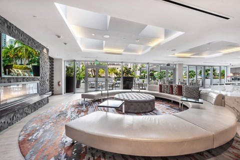 A modern living room with a large circular sofa and a fireplace.