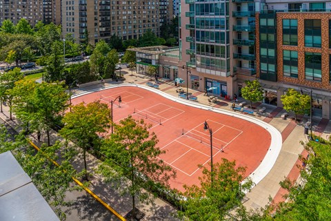 a tennis court in the middle of a city with buildings
