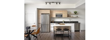 A modern kitchen with a dining table and chairs.