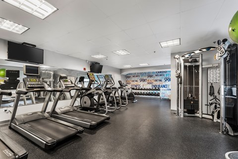 A gym with treadmills and other exercise equipment.