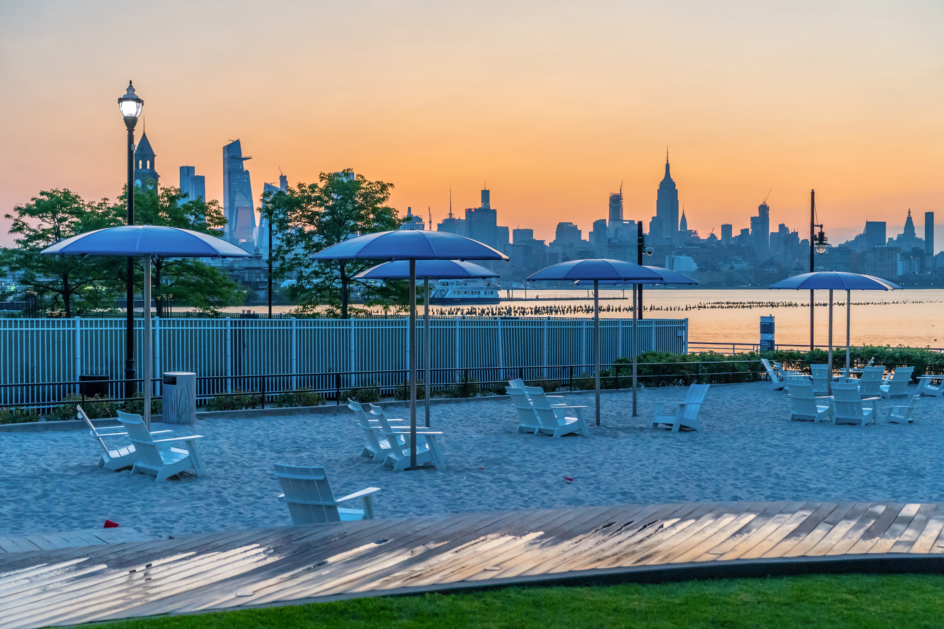 sunset view of manhattan on urban beach and boardwalk