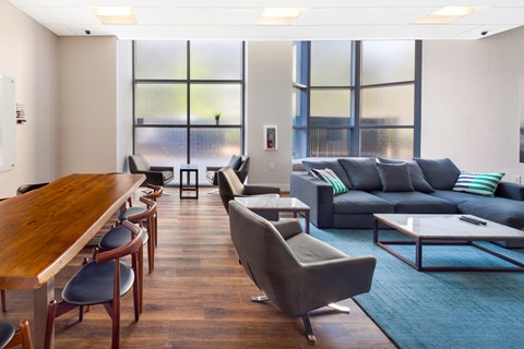 A living room with a grey couch and a wooden table.