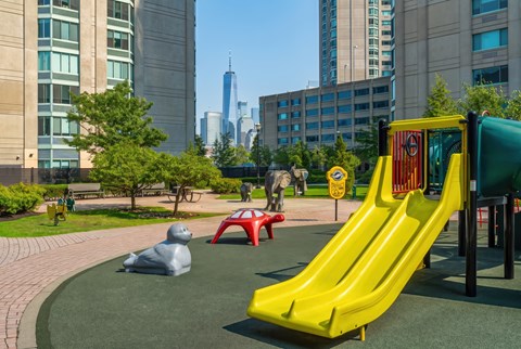 A playground with a yellow slide and a red and yellow ball pit.