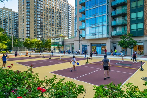A group of people playing tennis on a court.