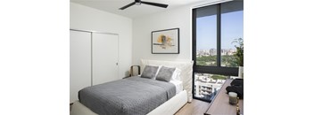 A bedroom with a large bed and a view of the city.