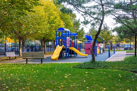 A playground with a yellow slide and a blue structure.