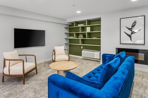 A living room with a blue couch, a wooden table, and a television.