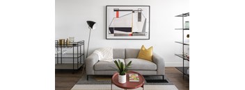 A grey couch with a white pillow and a yellow pillow on it.