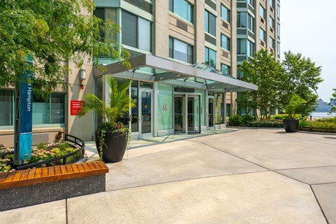 A building with a glass entrance and a red sign on the wall.