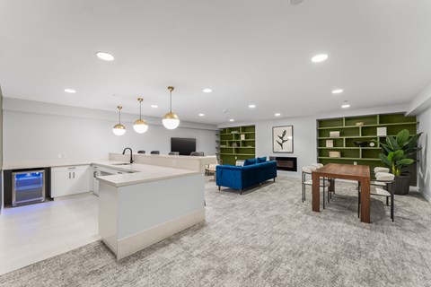 A modern kitchen with a white countertop and a blue sofa.