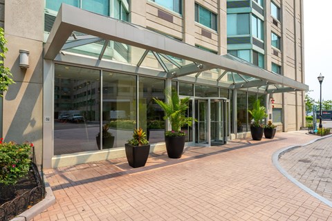 A building entrance with a glass wall and a metal awning.