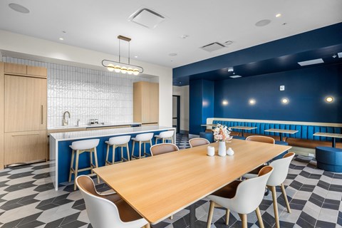 A modern dining room with a wooden table and white chairs.