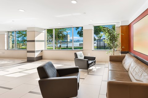 A living room with a couch, chairs and a large window.