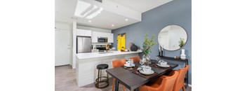 A modern kitchen with a dining table set for two.