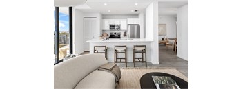 A modern kitchen with a breakfast bar and a couch.