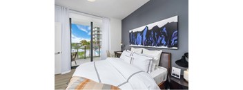 A bedroom with a large bed and a painting on the wall.