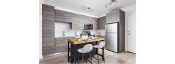A modern kitchen with a wooden table and chairs.