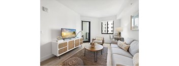 A modern living room with a flat screen TV and a grey sofa.