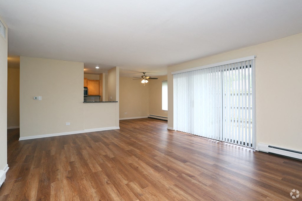 an empty living room with wood flooring and a large window