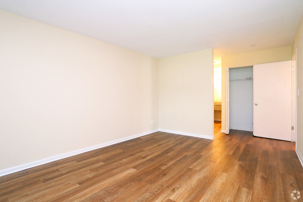 a empty living room with wood floors and white walls