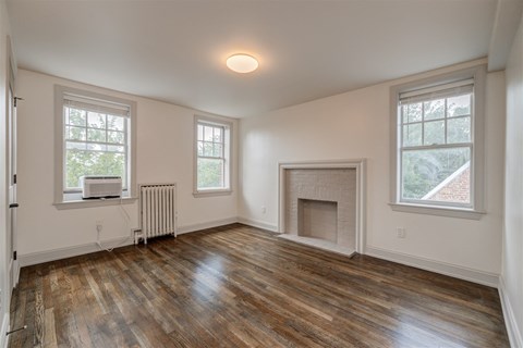 an empty living room with a fireplace and a tv