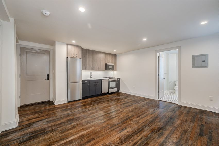 a living room with a kitchen and a door to a bathroom