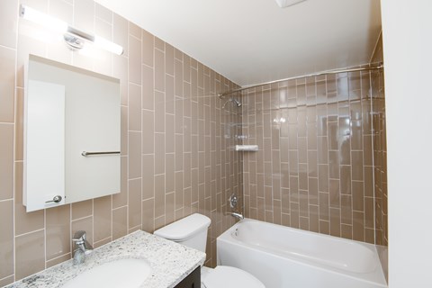 A bathroom with a white toilet, sink, and bathtub.