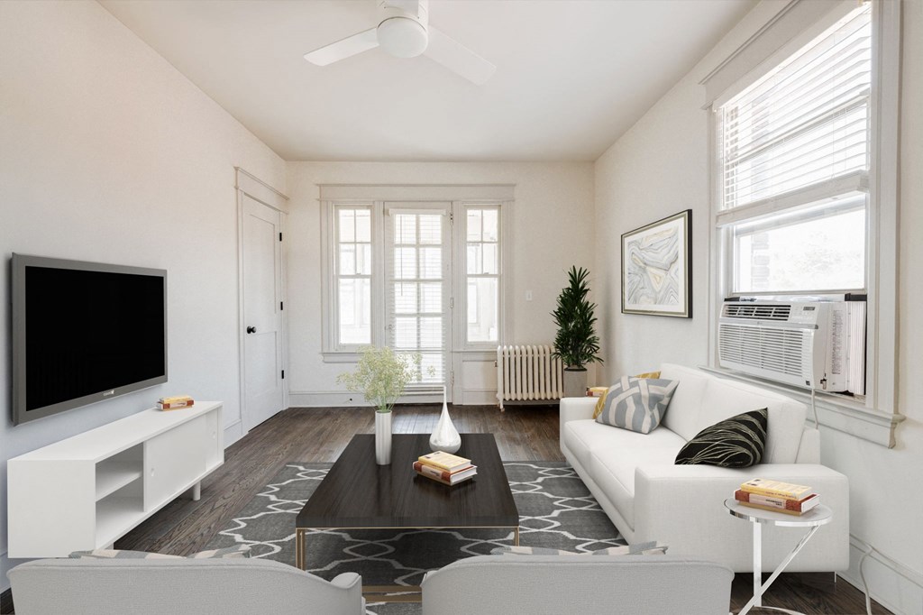 a living room with a white couch and a tv