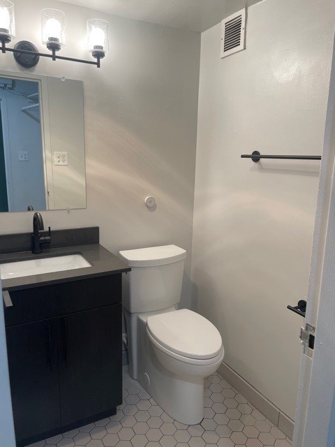 A white toilet sits next to a sink in a bathroom. at 2400 Pennsylvania Avenue Apartments, Washington, DC,20037