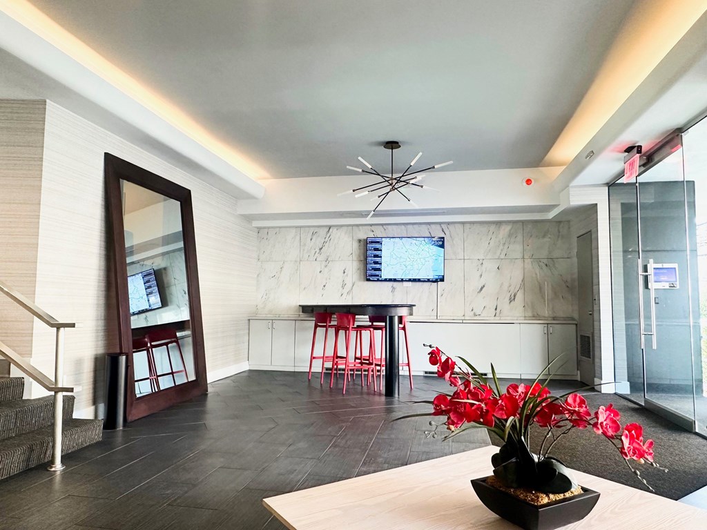 A modern living room with a wooden table and a vase of red flowers. at 2400 Pennsylvania Avenue Apartments, Washington, DC,20037