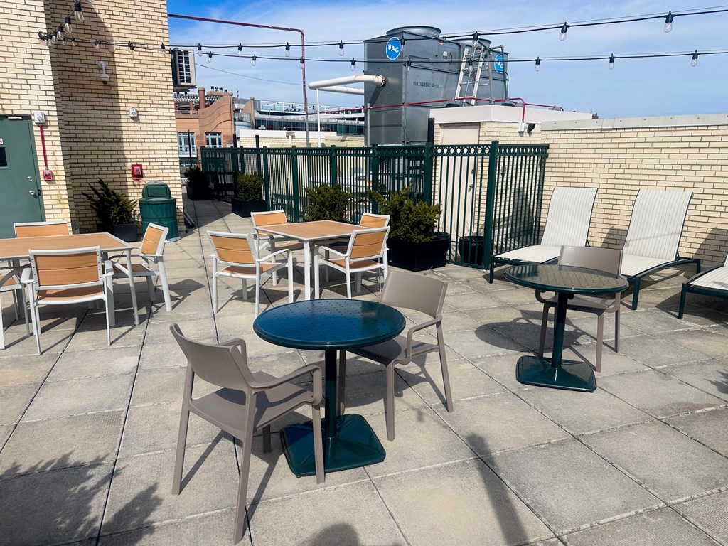 A patio with tables and chairs is set up. at 2400 Pennsylvania Avenue Apartments, Washington, DC,20037