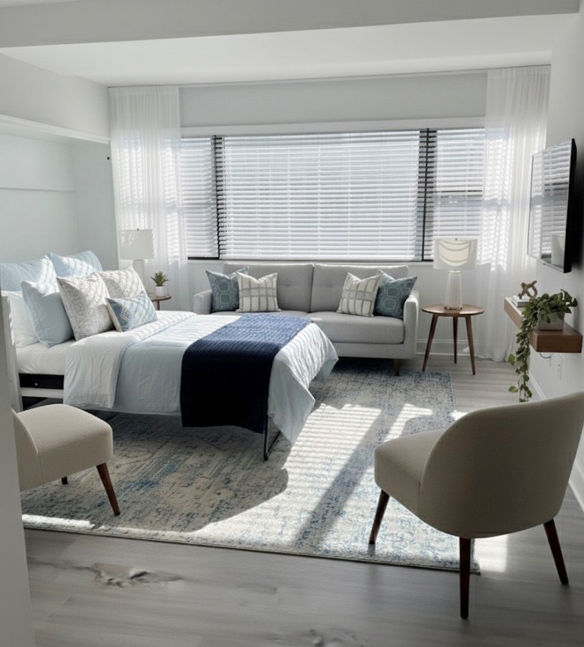 A bedroom with a bed, a couch, and a chair.