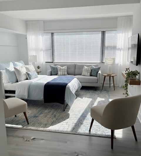 A bedroom with a bed, a couch, and a chair.