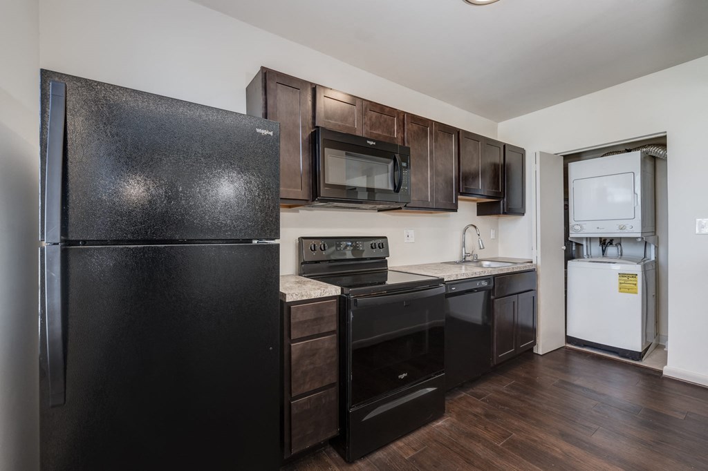 a kitchen with black appliances and dark wood cabinets