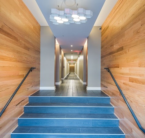 A long hallway with wooden walls and steps leading to the end.