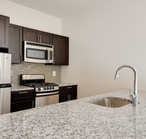 A kitchen with granite countertops and stainless steel appliances.