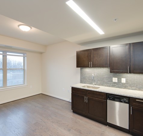 A kitchen with brown cabinets and a white sink.