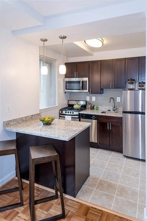 a kitchen with a marble counter top and stainless steel appliances