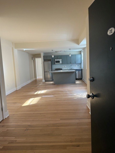 A kitchen with a black door and a white wall.